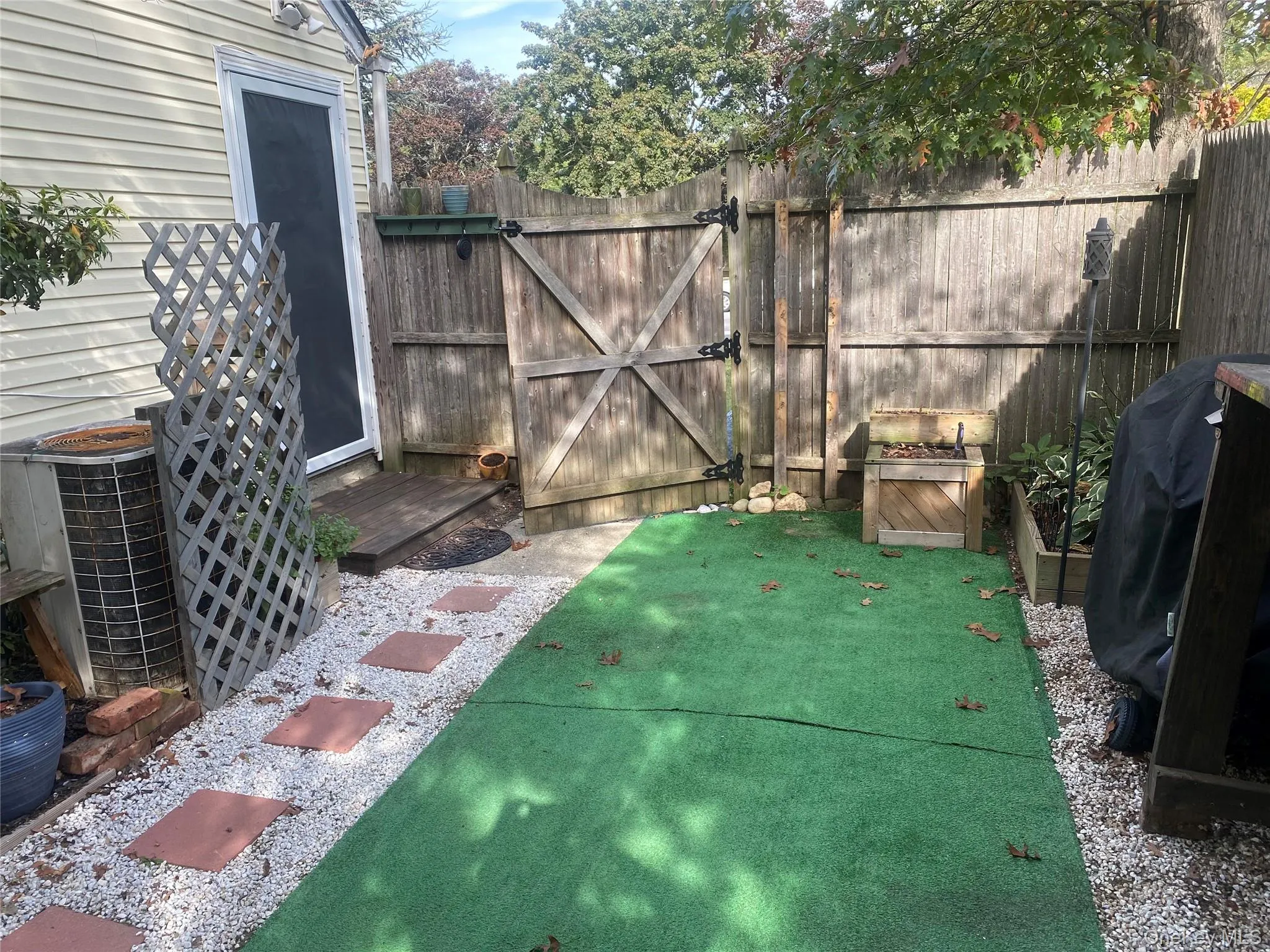 View of patio / terrace with a gate, a wooden deck, and area for grilling View of patio / terrace with a gate, a wooden deck, and area for grilling