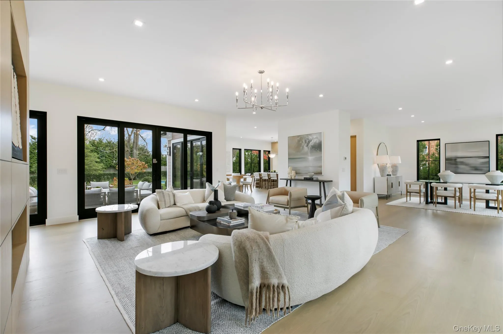 Living room featuring recessed lighting, a chandelier, plenty of natural light, and light wood-style flooring Living room featuring recessed lighting, a chandelier, plenty of natural light, and light wood-style flooring