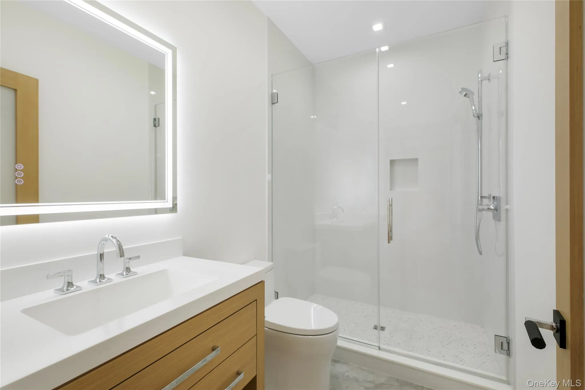 Bathroom featuring a shower stall and vanity Bathroom featuring a shower stall and vanity