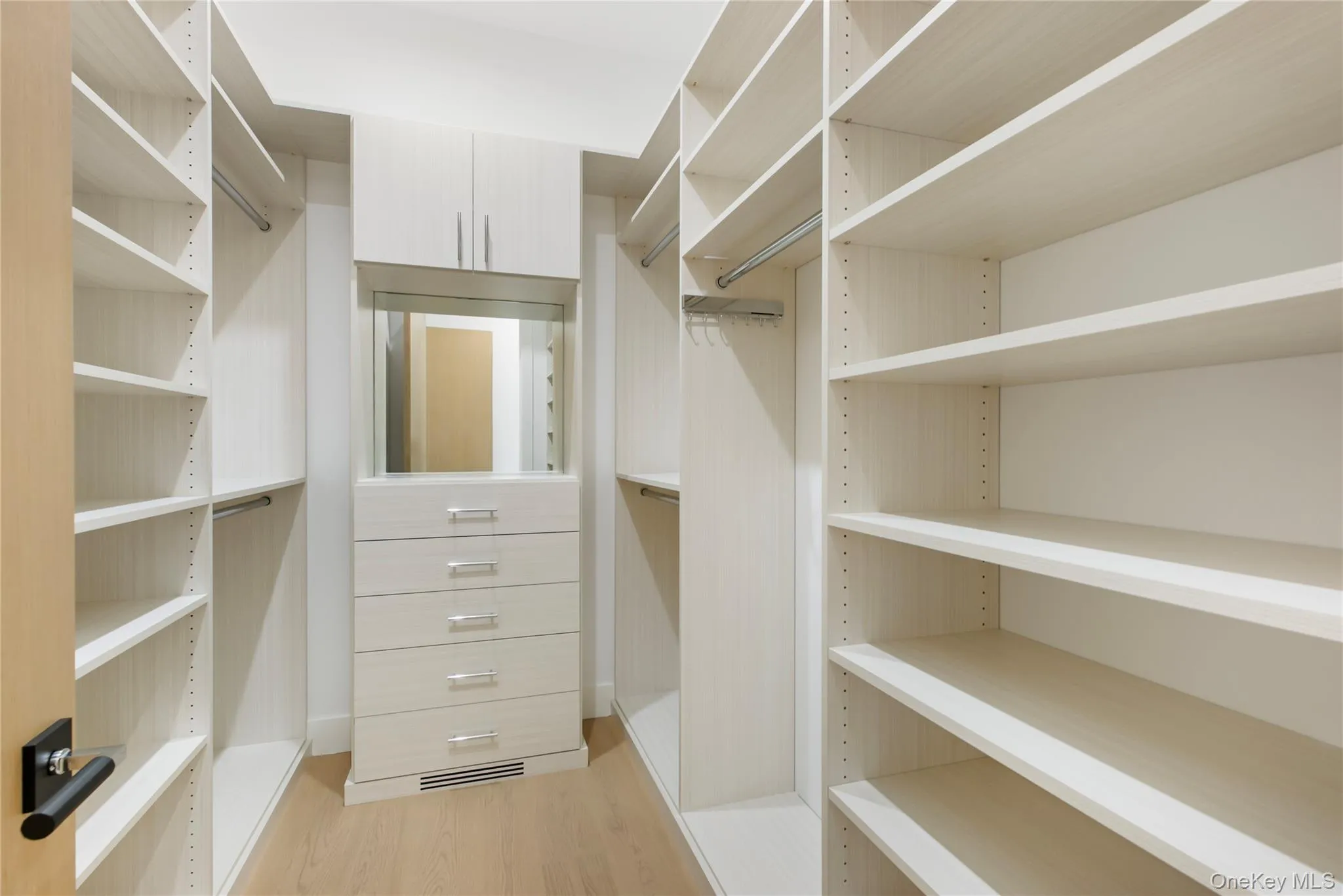 Spacious closet with light wood-type flooring Spacious closet with light wood-type flooring