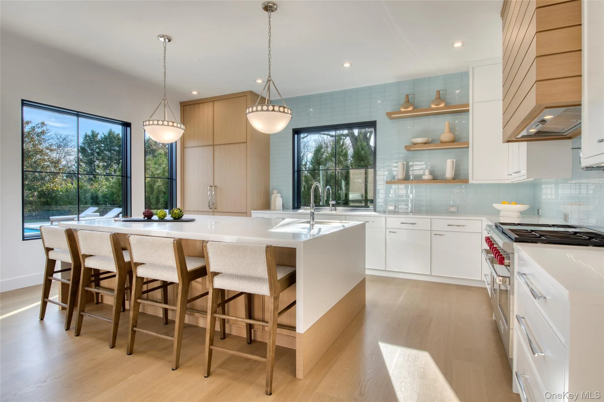 Kitchen featuring double oven range, open shelves, modern cabinets, custom exhaust hood, and tasteful backsplash Kitchen featuring double oven range, open shelves, modern cabinets, custom exhaust hood, and tasteful backsplash