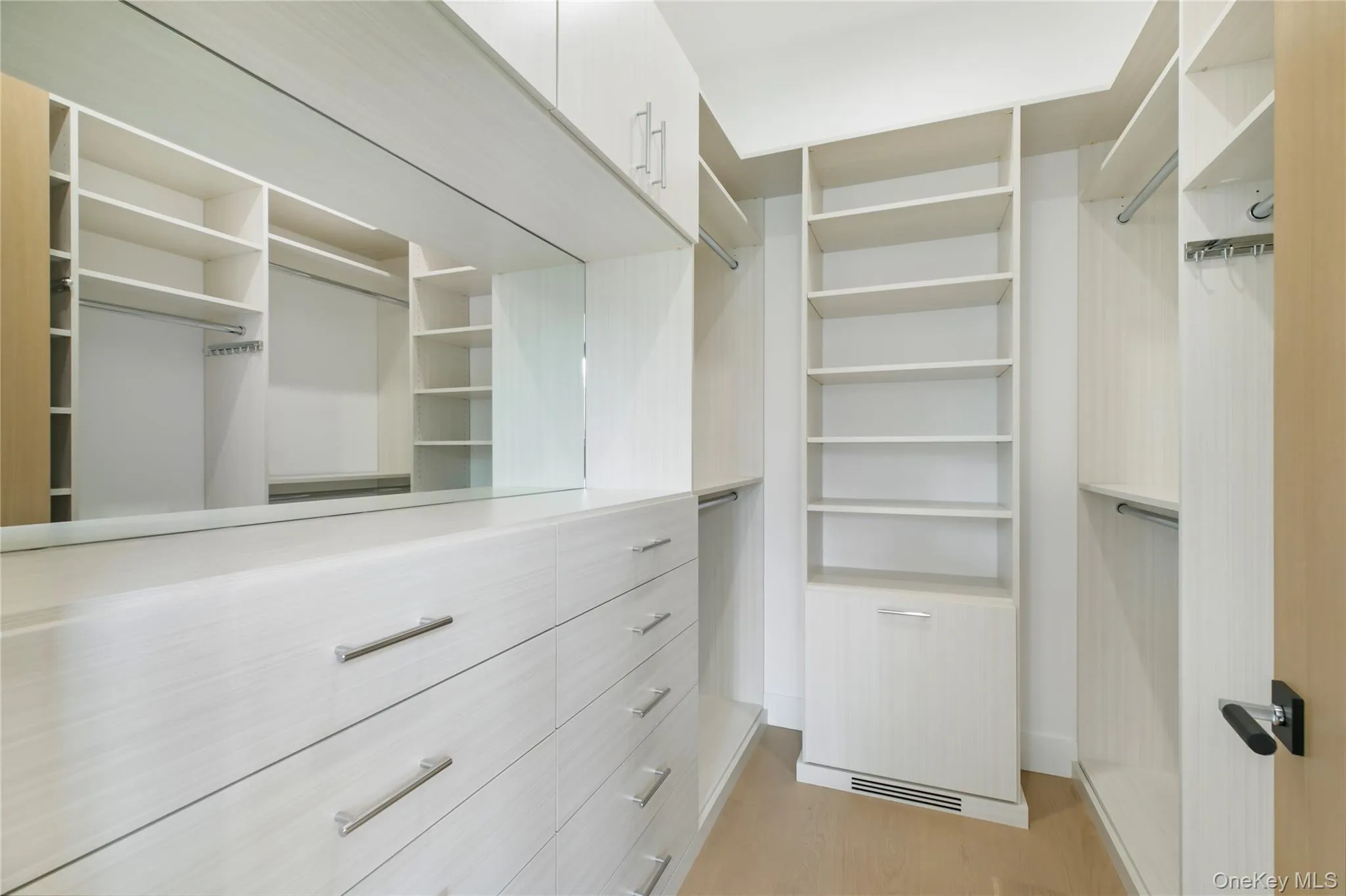 Walk in closet with light wood-style floors Walk in closet with light wood-style floors