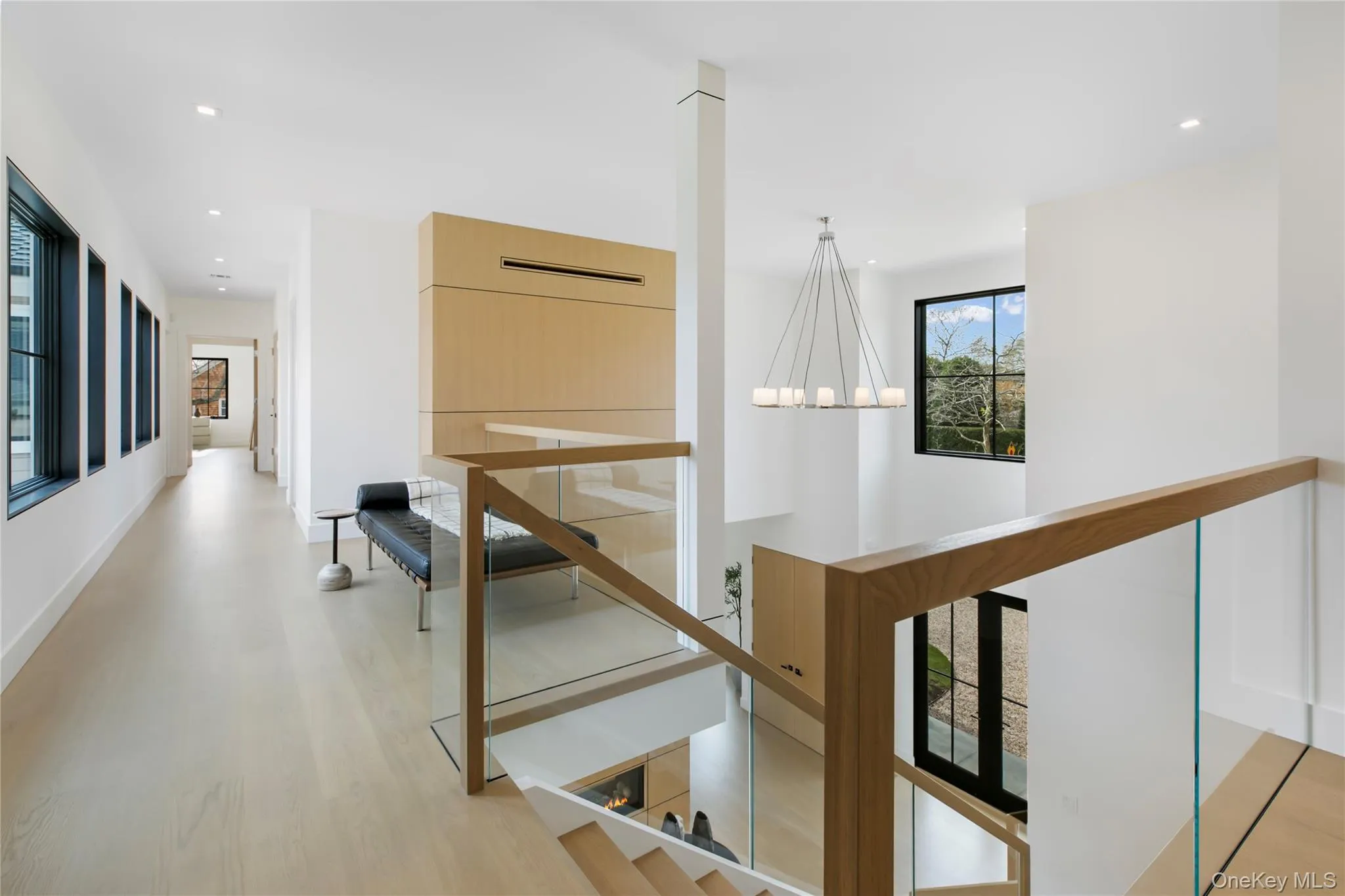 Hall with light wood finished floors, recessed lighting, and a chandelier Hall with light wood finished floors, recessed lighting, and a chandelier