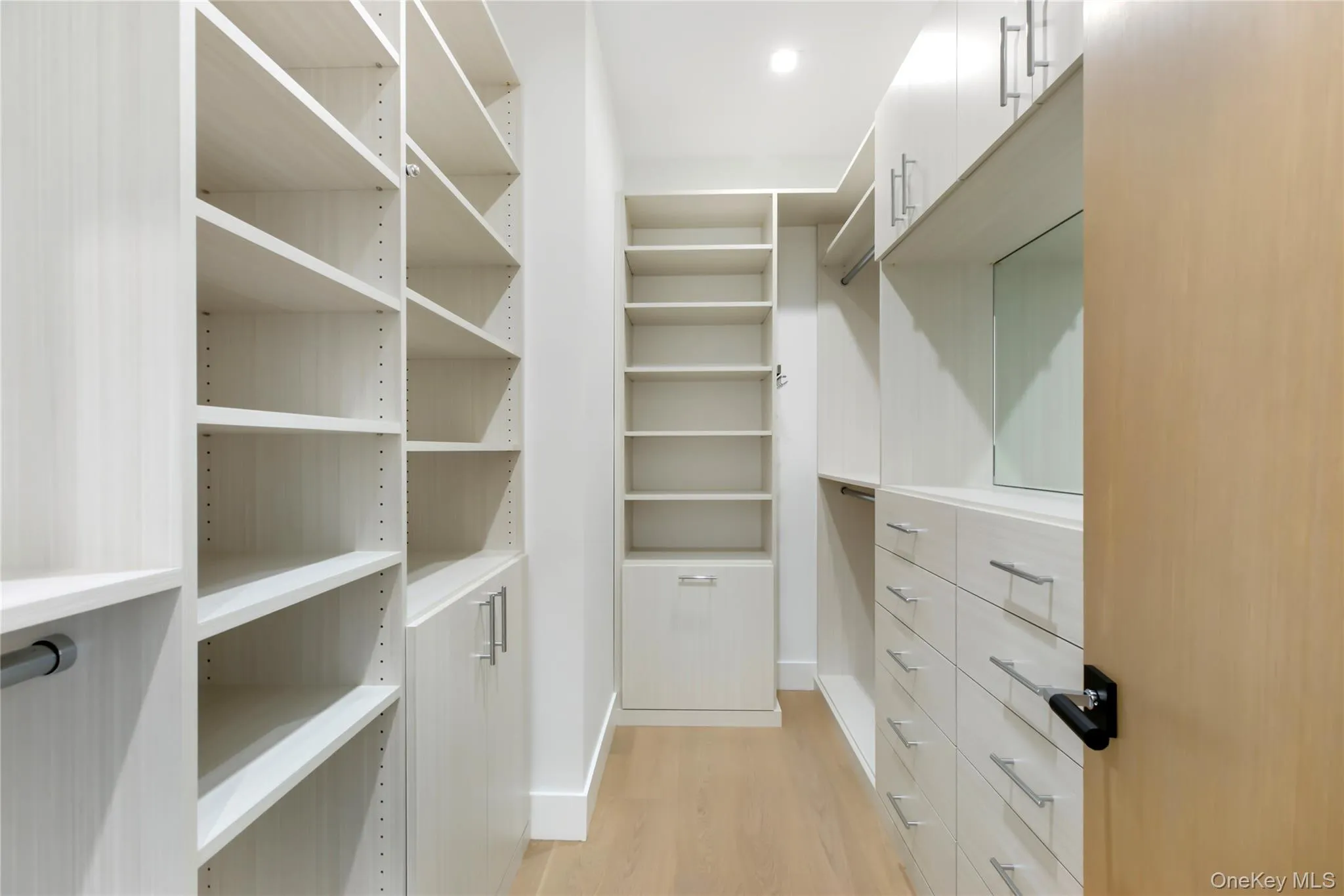 Walk in closet featuring light wood-style flooring Walk in closet featuring light wood-style flooring