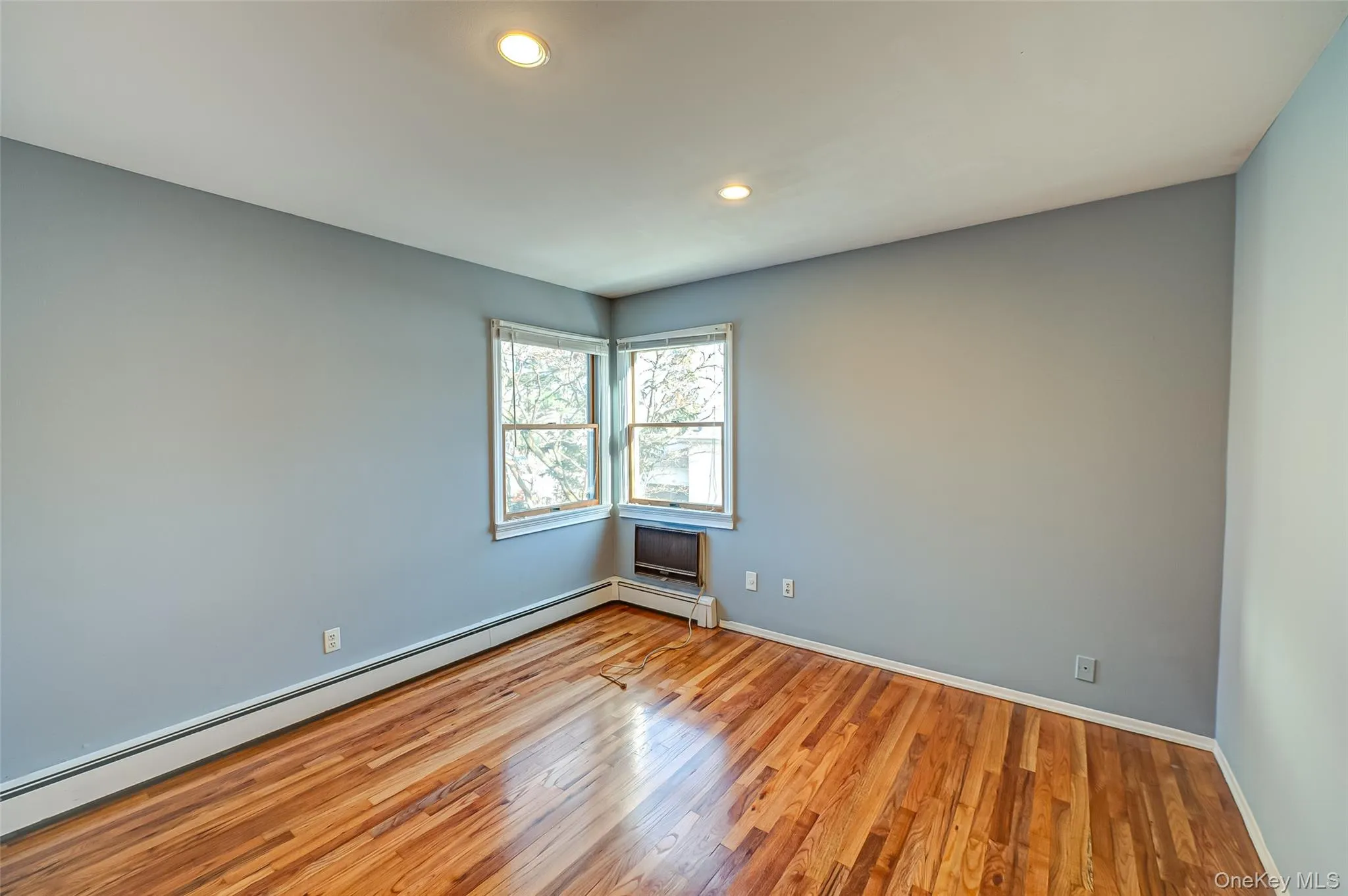 Unfurnished room featuring light hardwood / wood-style flooring and baseboard heating Unfurnished room featuring light hardwood / wood-style flooring and baseboard heating