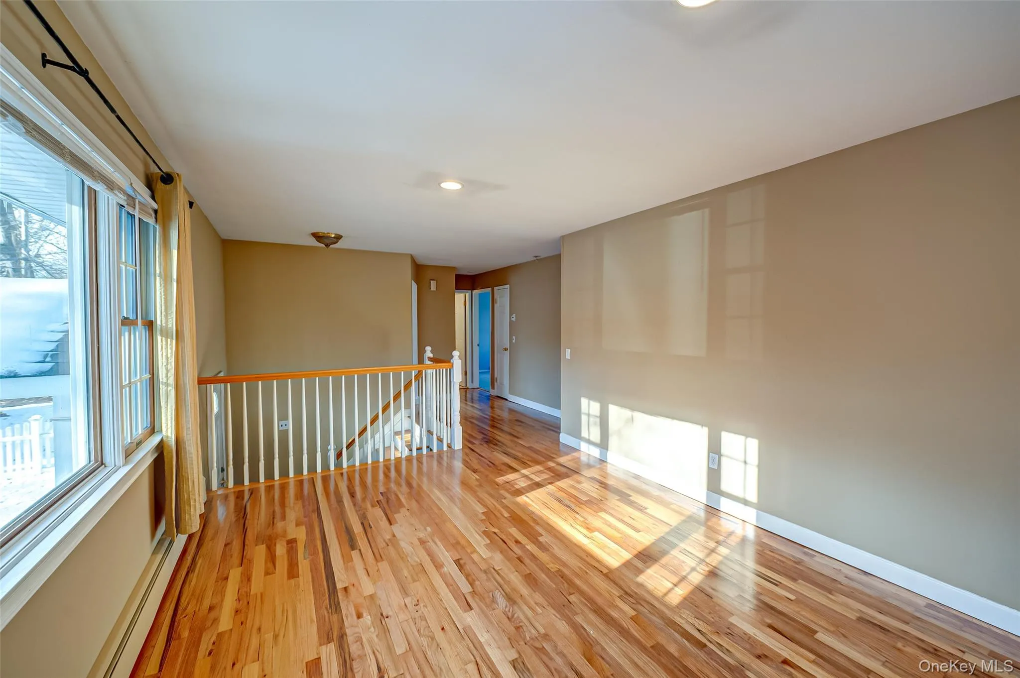 Empty room featuring light hardwood / wood-style floors and a baseboard heating unit Empty room featuring light hardwood / wood-style floors and a baseboard heating unit