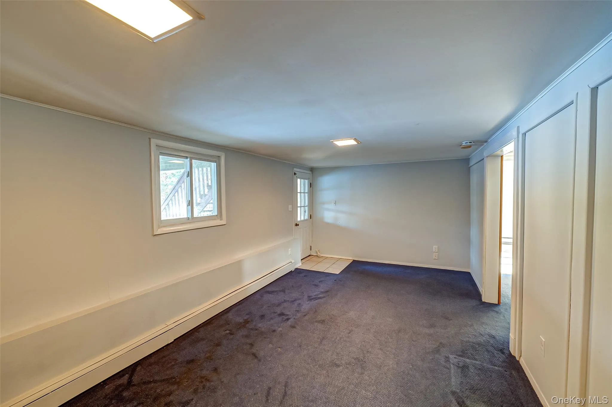 Carpeted spare room featuring a baseboard radiator Carpeted spare room featuring a baseboard radiator