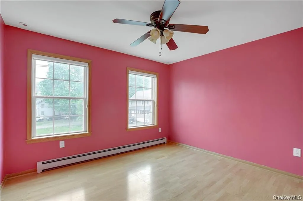 Spare room with a baseboard heating unit, light wood-style floors, and a ceiling fan Spare room with a baseboard heating unit, light wood-style floors, and a ceiling fan