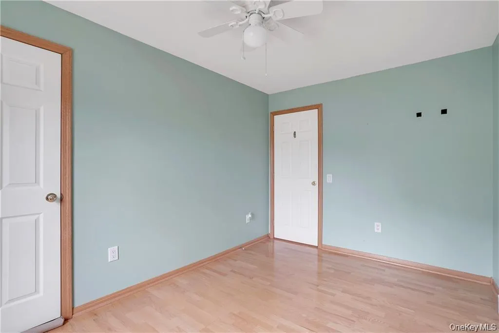 Empty room featuring light wood finished floors and a ceiling fan Empty room featuring light wood finished floors and a ceiling fan