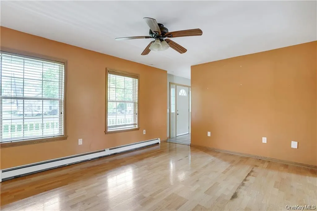 Spare room featuring a baseboard heating unit, light wood finished floors, and a ceiling fan Spare room featuring a baseboard heating unit, light wood finished floors, and a ceiling fan