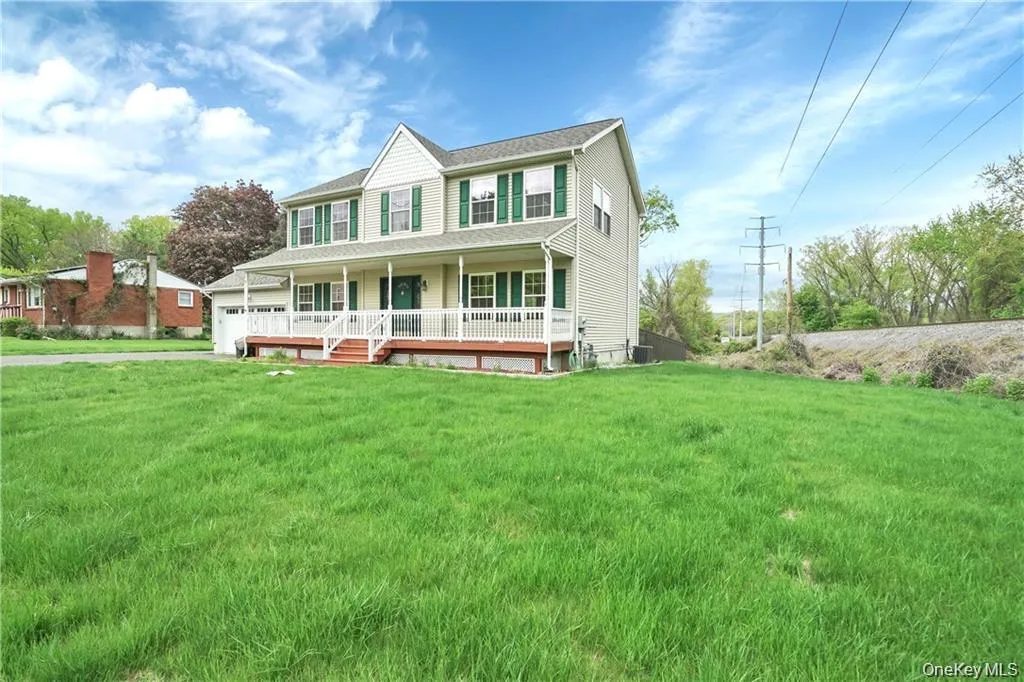 View of front of home with covered porch, a front lawn, and a garage View of front of home with covered porch, a front lawn, and a garage