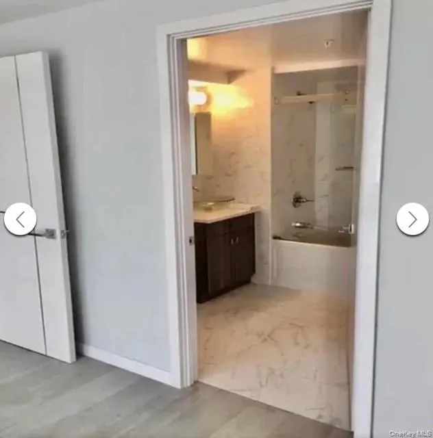 Bathroom with vanity, shower / bathtub combination, and light wood-type flooring Bathroom with vanity, shower / bathtub combination, and light wood-type flooring