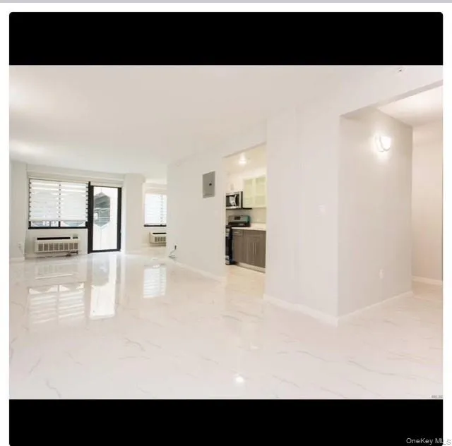 Spare room with light marble finish flooring and baseboards Spare room with light marble finish flooring and baseboards