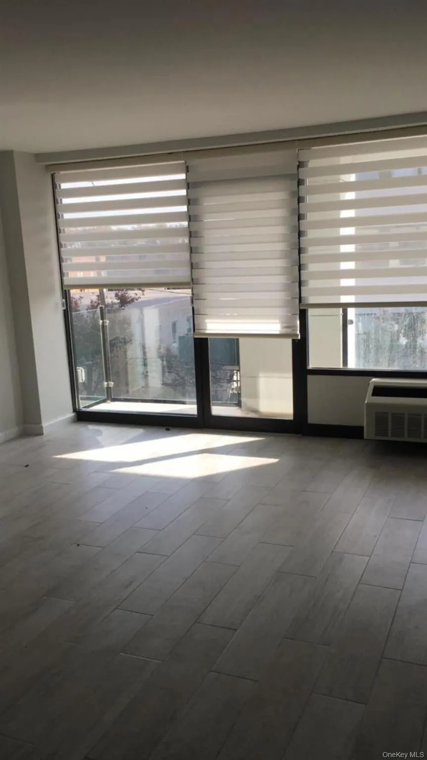 Empty room featuring dark wood finished floors and radiator heating unit Empty room featuring dark wood finished floors and radiator heating unit