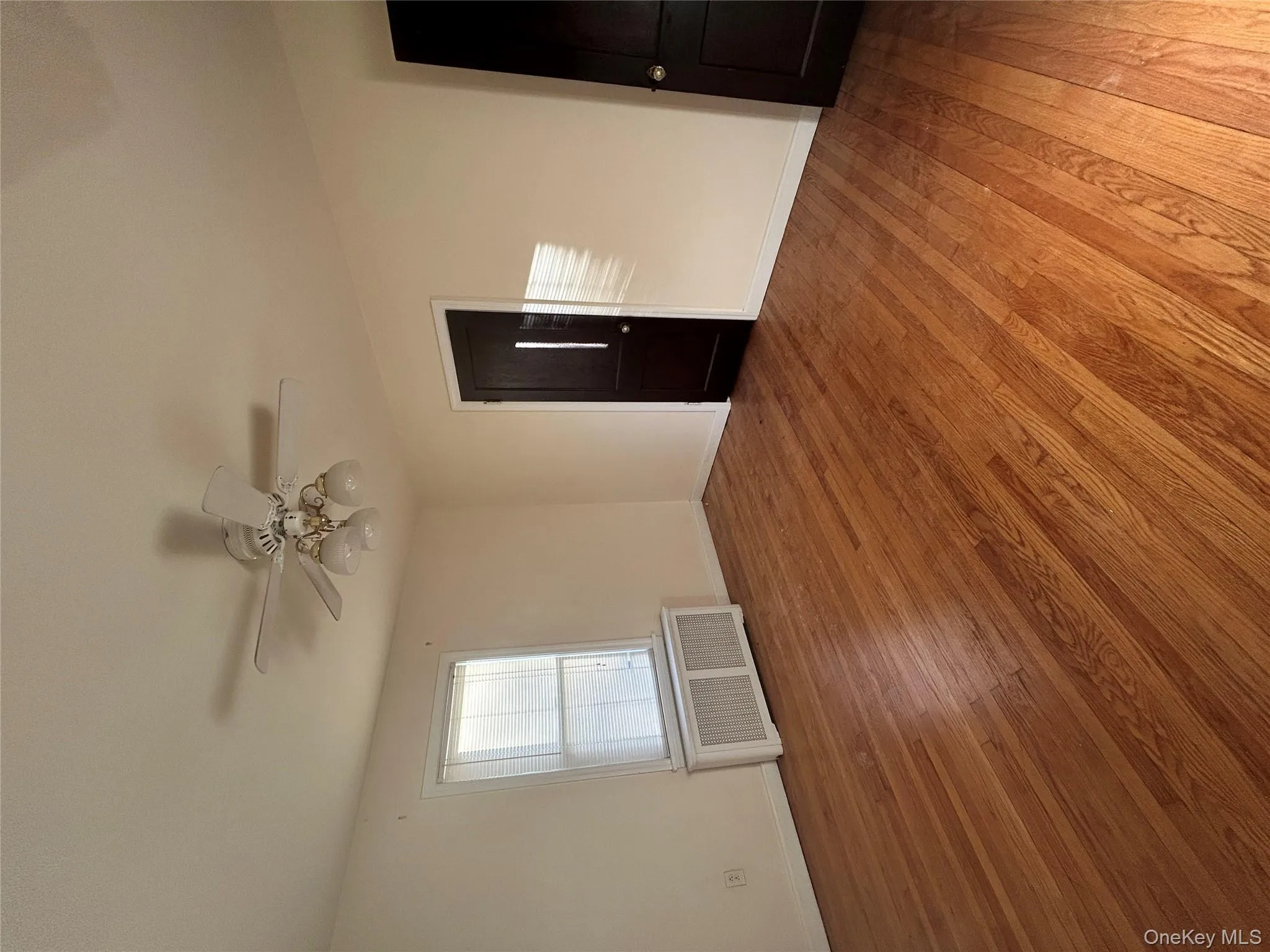 Empty room featuring light wood-style flooring, radiator, and ceiling fan Empty room featuring light wood-style flooring, radiator, and ceiling fan