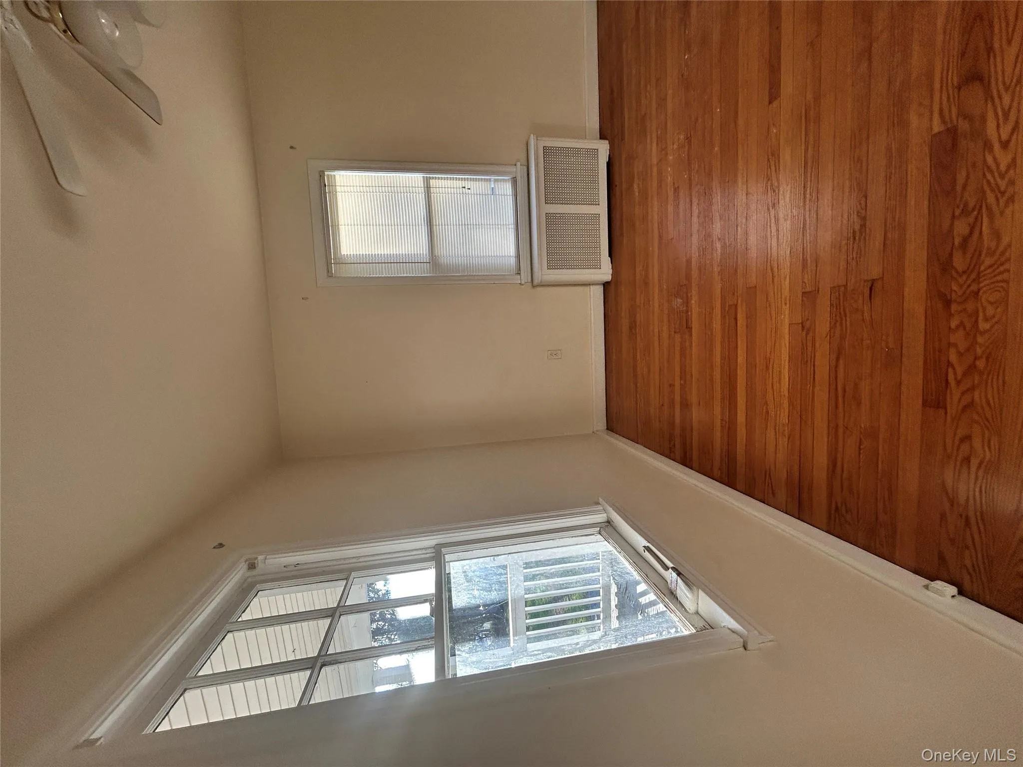 Spare room with radiator heating unit, wood finished floors, and a ceiling fan Spare room with radiator heating unit, wood finished floors, and a ceiling fan