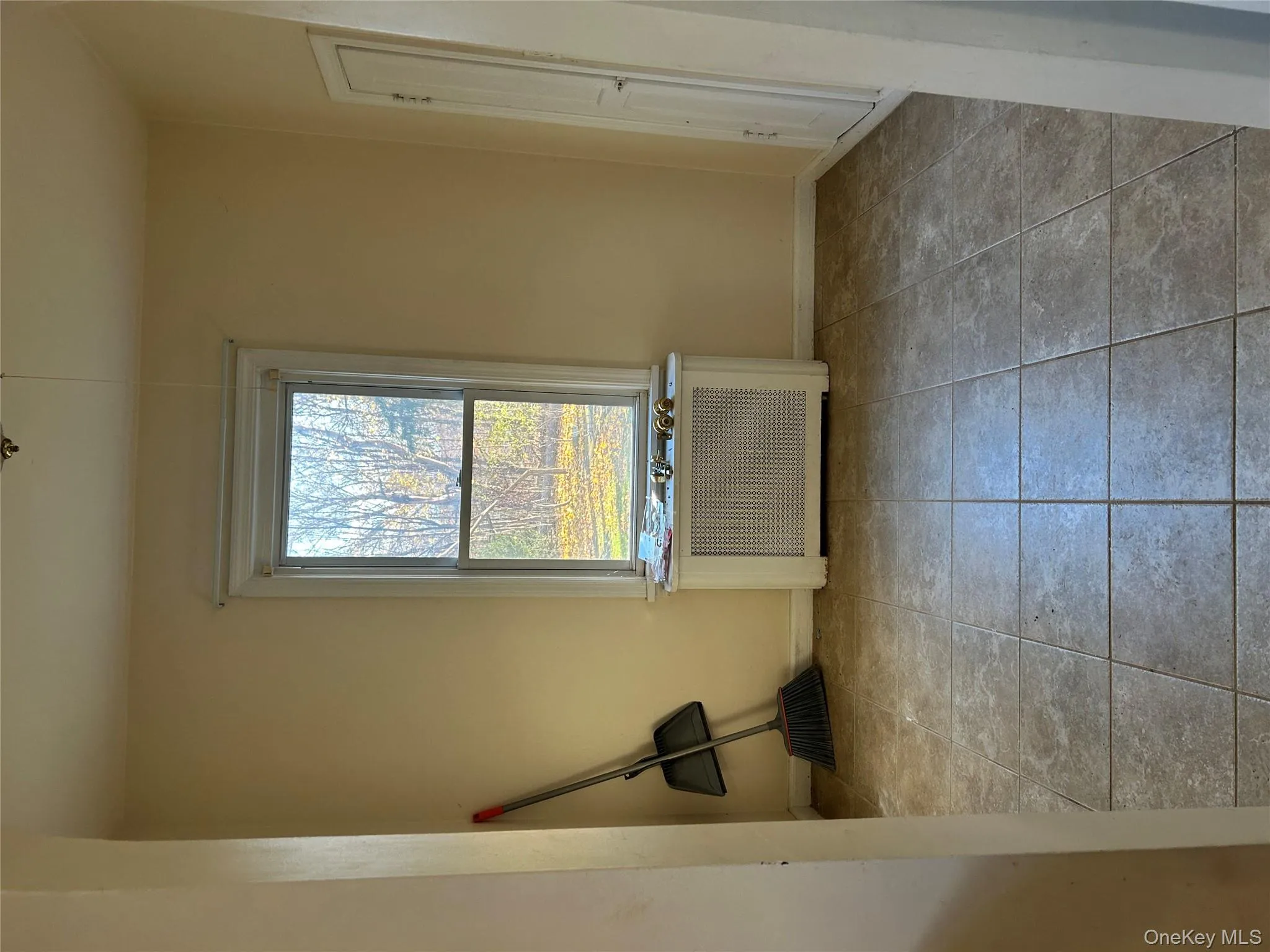 Unfurnished dining area featuring radiator heating unit and light tile patterned flooring Unfurnished dining area featuring radiator heating unit and light tile patterned flooring