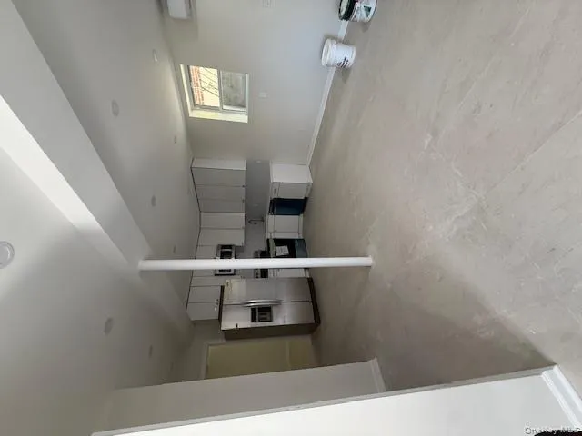 Below grade area with fridge and a wall mounted AC Below grade area with fridge and a wall mounted AC