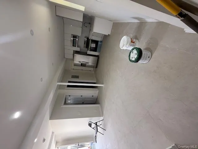 Kitchen with open floor plan, range, light countertops, refrigerator, and white cabinetry Kitchen with open floor plan, range, light countertops, refrigerator, and white cabinetry