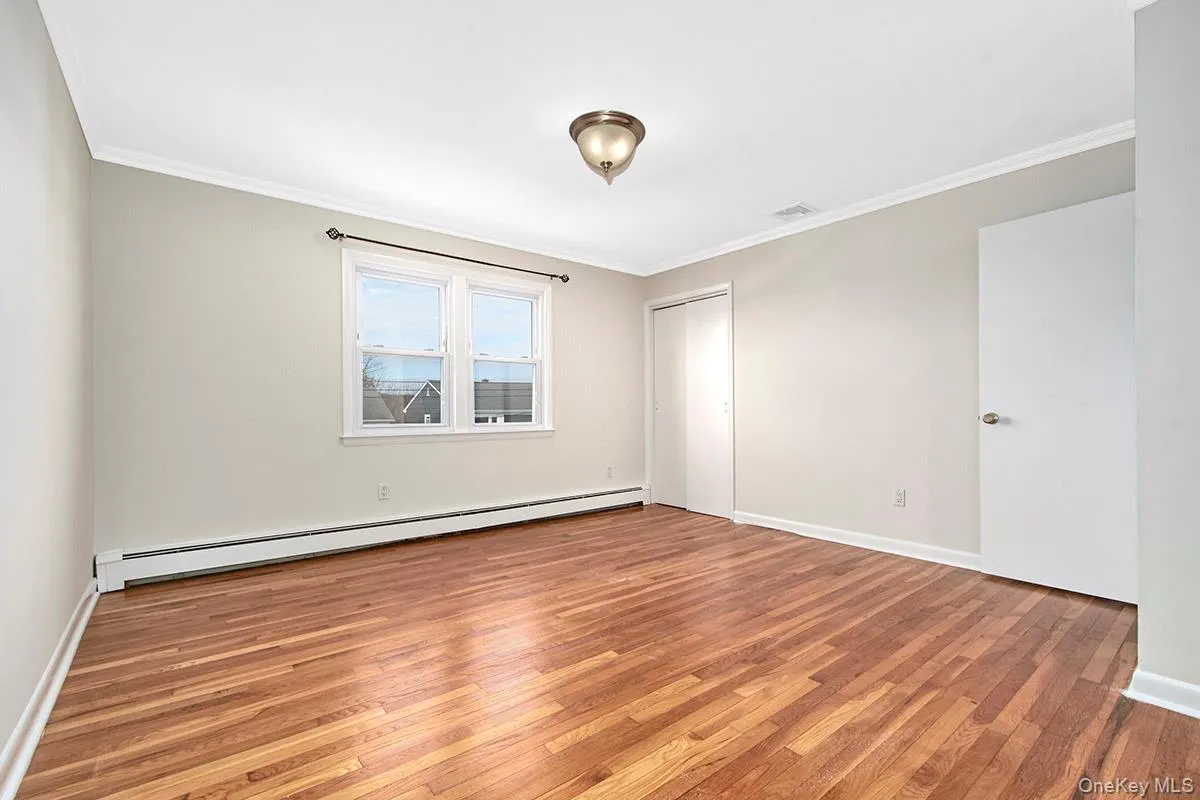 Unfurnished bedroom featuring wood finished floors Unfurnished bedroom featuring wood finished floors