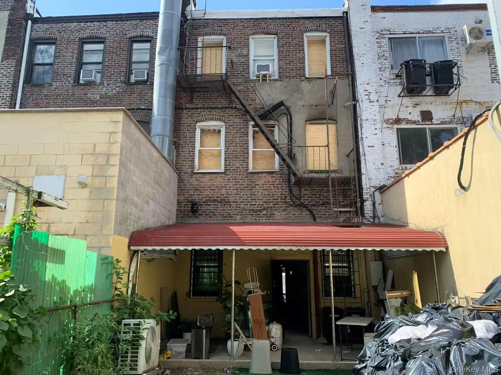 Rear view of property featuring a patio area, brick siding, and a balcony Rear view of property featuring a patio area, brick siding, and a balcony