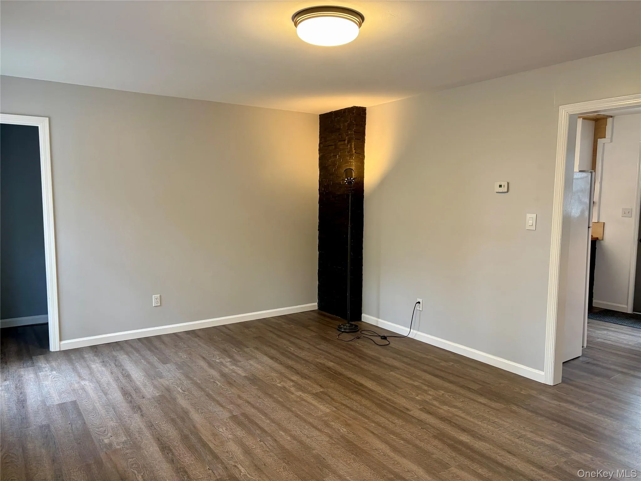 Unfurnished room featuring baseboards and dark wood-type flooring Unfurnished room featuring baseboards and dark wood-type flooring