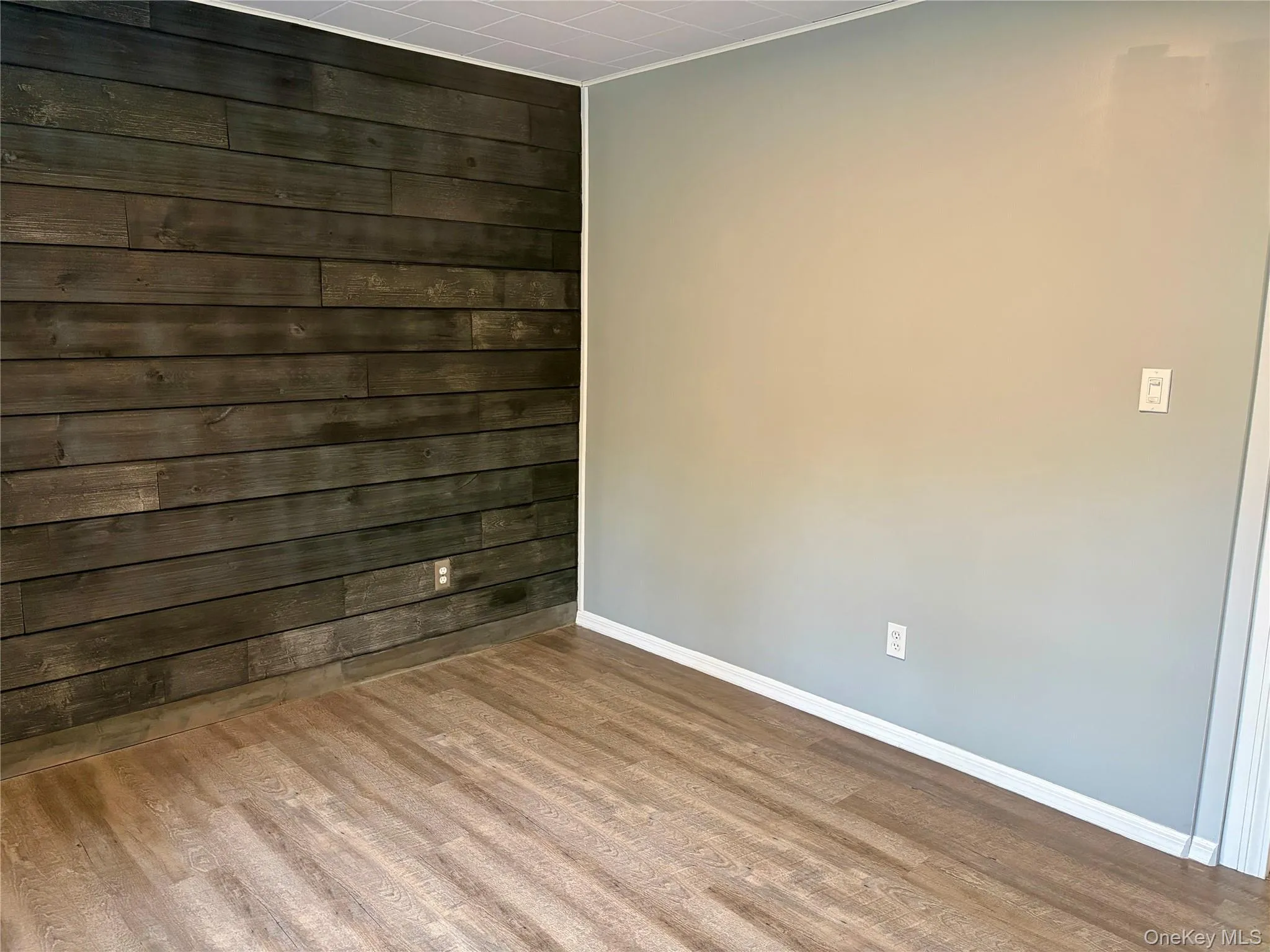 Spare room with wood walls and wood finished floors Spare room with wood walls and wood finished floors