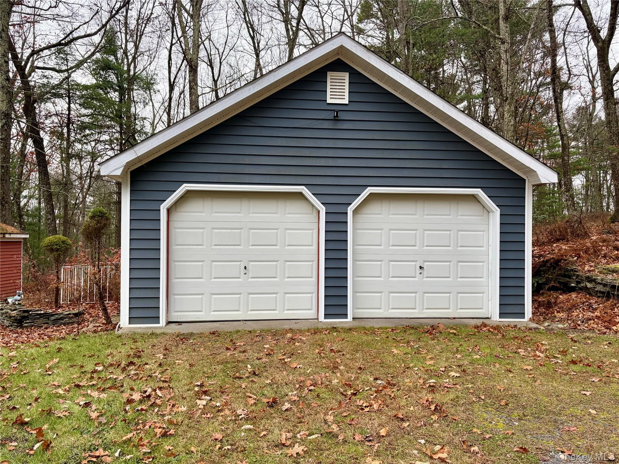 Detached garage featuring view of wooded area Detached garage featuring view of wooded area