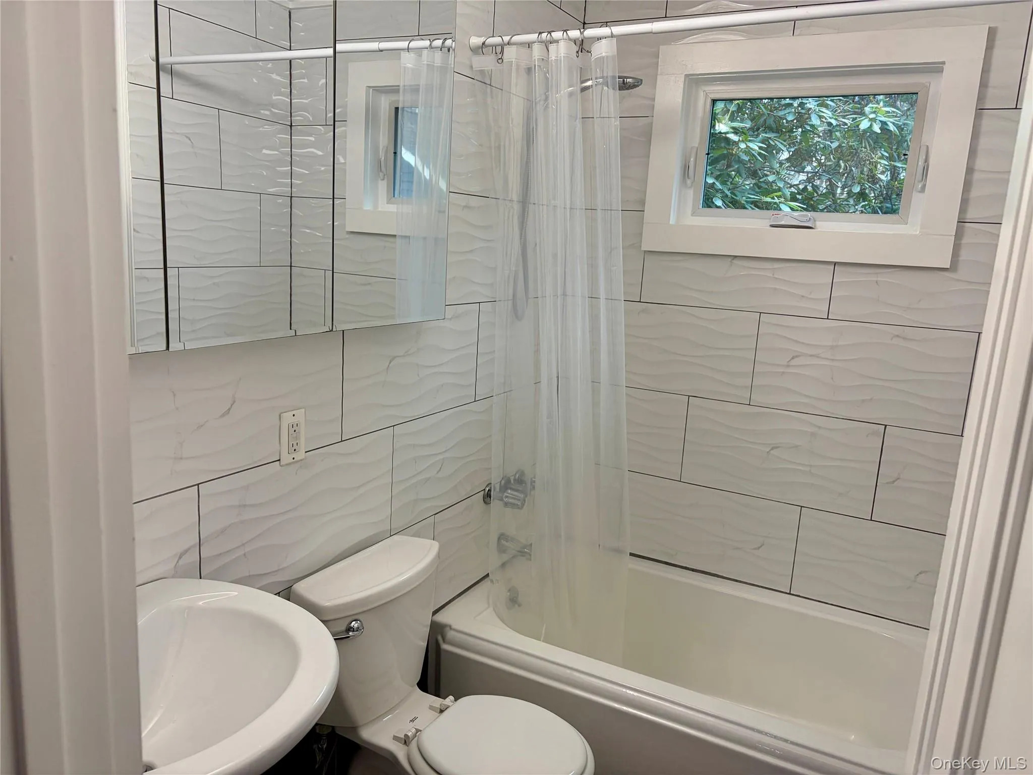 Bathroom with shower / bath combo and tile walls Bathroom with shower / bath combo and tile walls