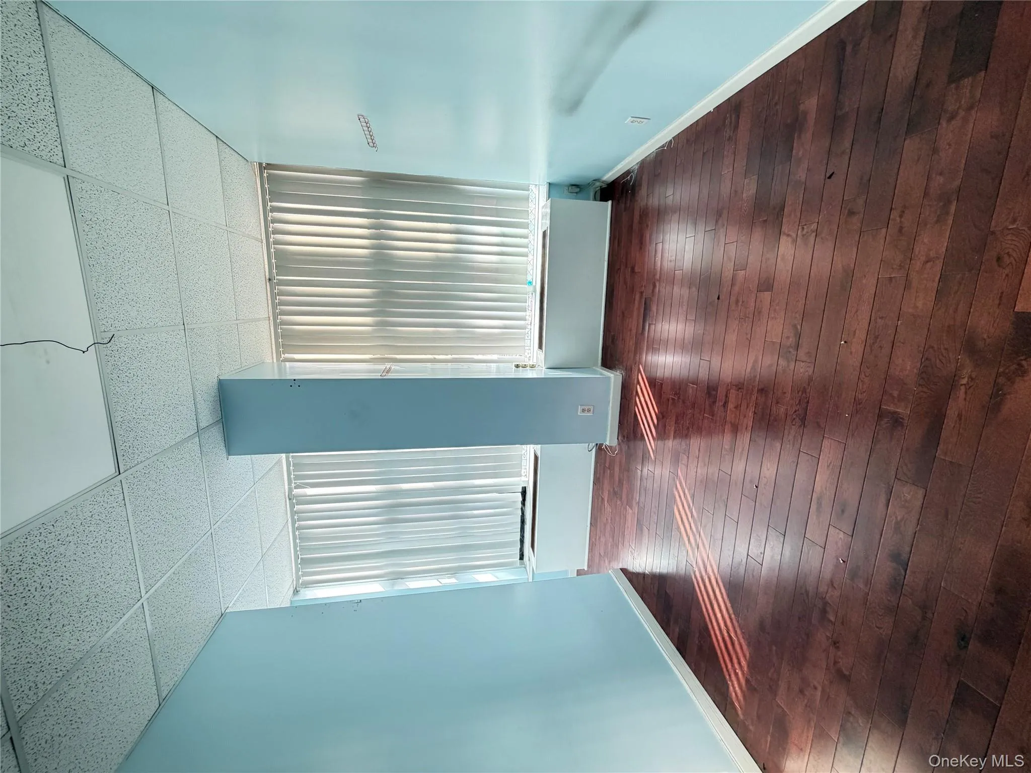 Unfurnished room featuring a paneled ceiling and dark wood-style floors Unfurnished room featuring a paneled ceiling and dark wood-style floors