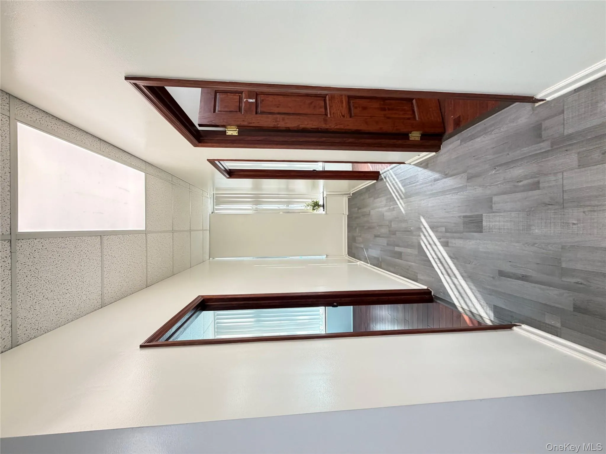 Hallway featuring a drop ceiling and wood finished floors Hallway featuring a drop ceiling and wood finished floors