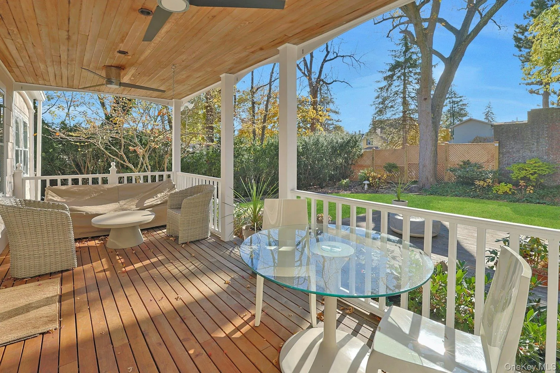 Wooden terrace with outdoor dining space, a fenced backyard, and a ceiling fan Wooden terrace with outdoor dining space, a fenced backyard, and a ceiling fan