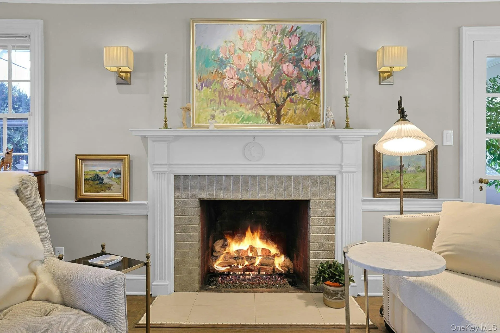 Sitting room featuring plenty of natural light, a brick fireplace, and wood finished floors Sitting room featuring plenty of natural light, a brick fireplace, and wood finished floors
