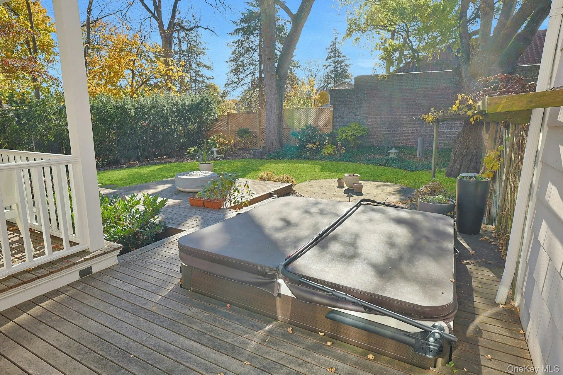 Deck with a fenced backyard and a covered hot tub Deck with a fenced backyard and a covered hot tub