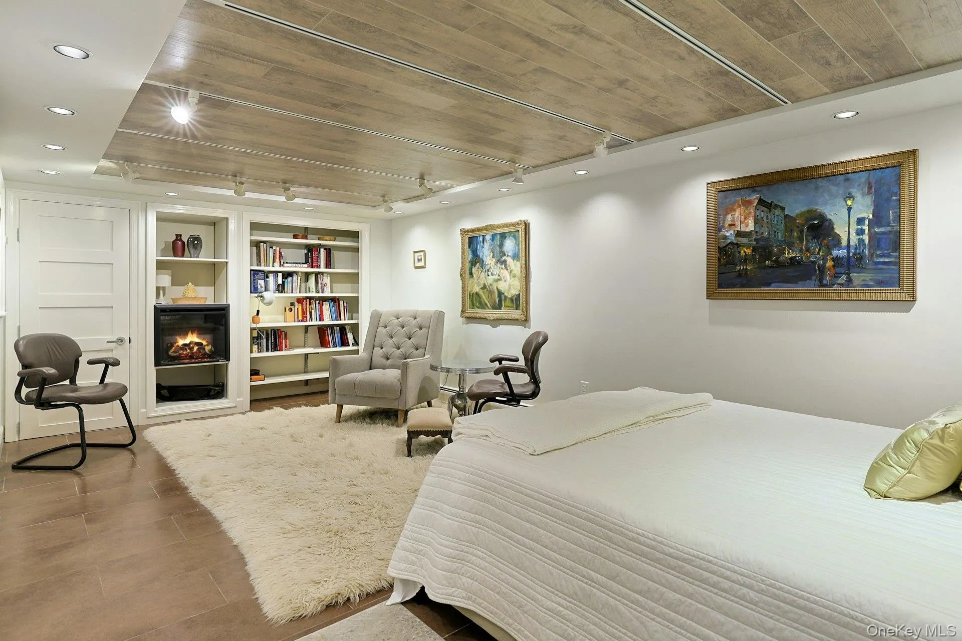 Bedroom with wood ceiling, a lit fireplace, recessed lighting, and track lighting Bedroom with wood ceiling, a lit fireplace, recessed lighting, and track lighting