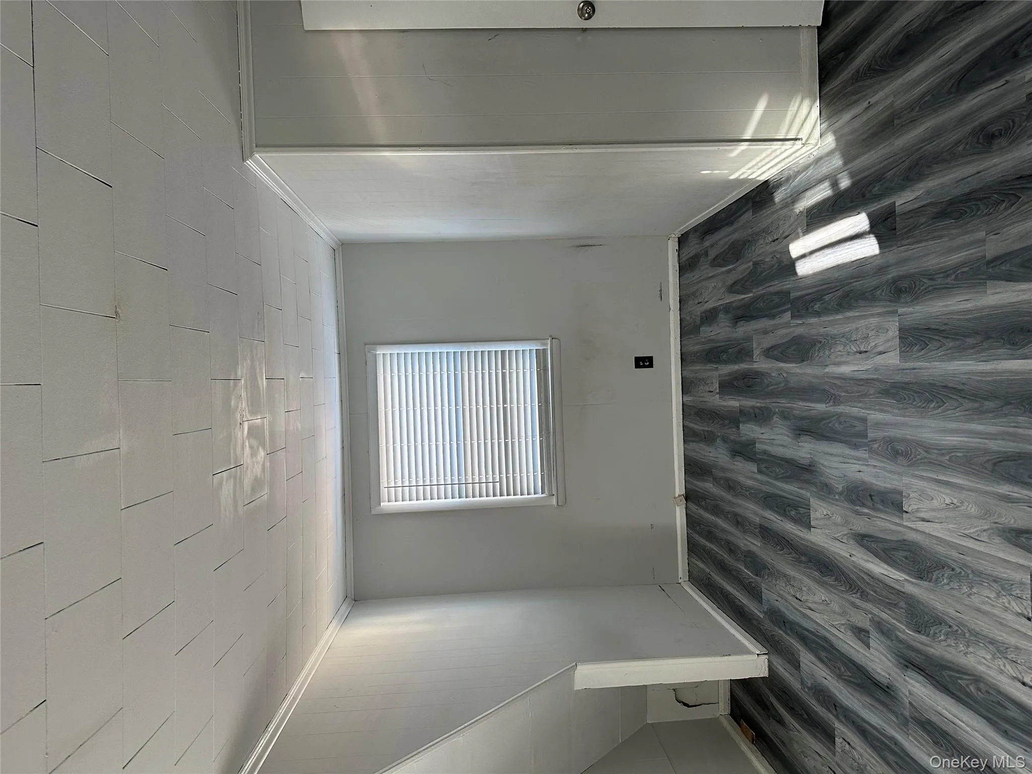 Empty room with ornamental molding, dark wood-type flooring, and wood walls Empty room with ornamental molding, dark wood-type flooring, and wood walls