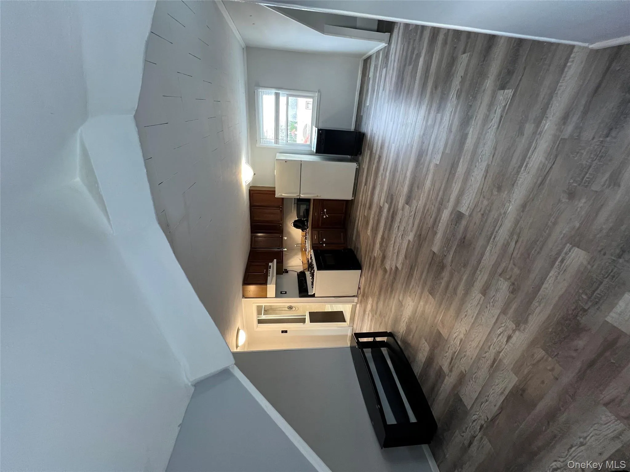 Unfurnished living room featuring baseboards and dark wood-type flooring Unfurnished living room featuring baseboards and dark wood-type flooring