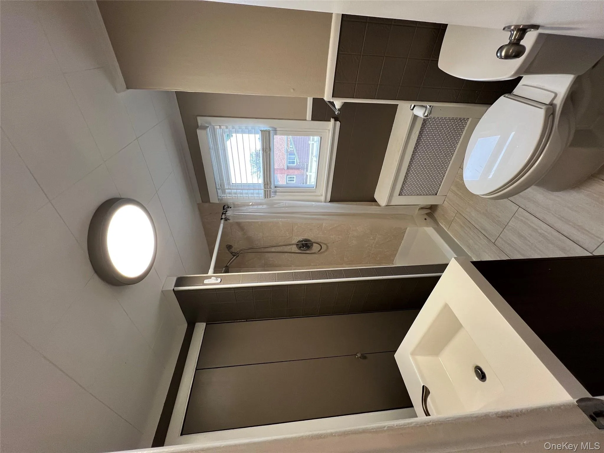 Full bathroom with a stall shower, radiator heating unit, vanity, and wainscoting Full bathroom with a stall shower, radiator heating unit, vanity, and wainscoting