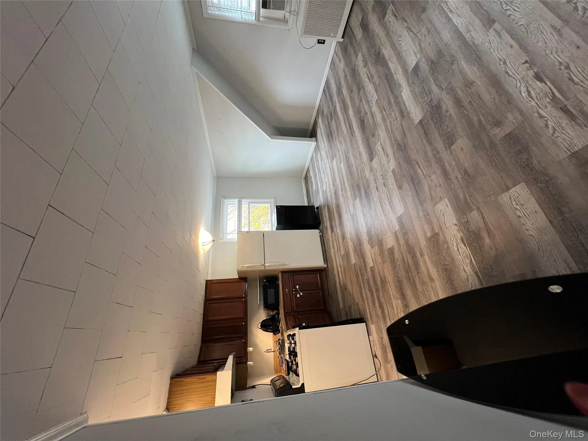 Kitchen featuring stove, freestanding refrigerator, dark brown cabinets, wood finished floors, and radiator heating unit Kitchen featuring stove, freestanding refrigerator, dark brown cabinets, wood finished floors, and radiator heating unit