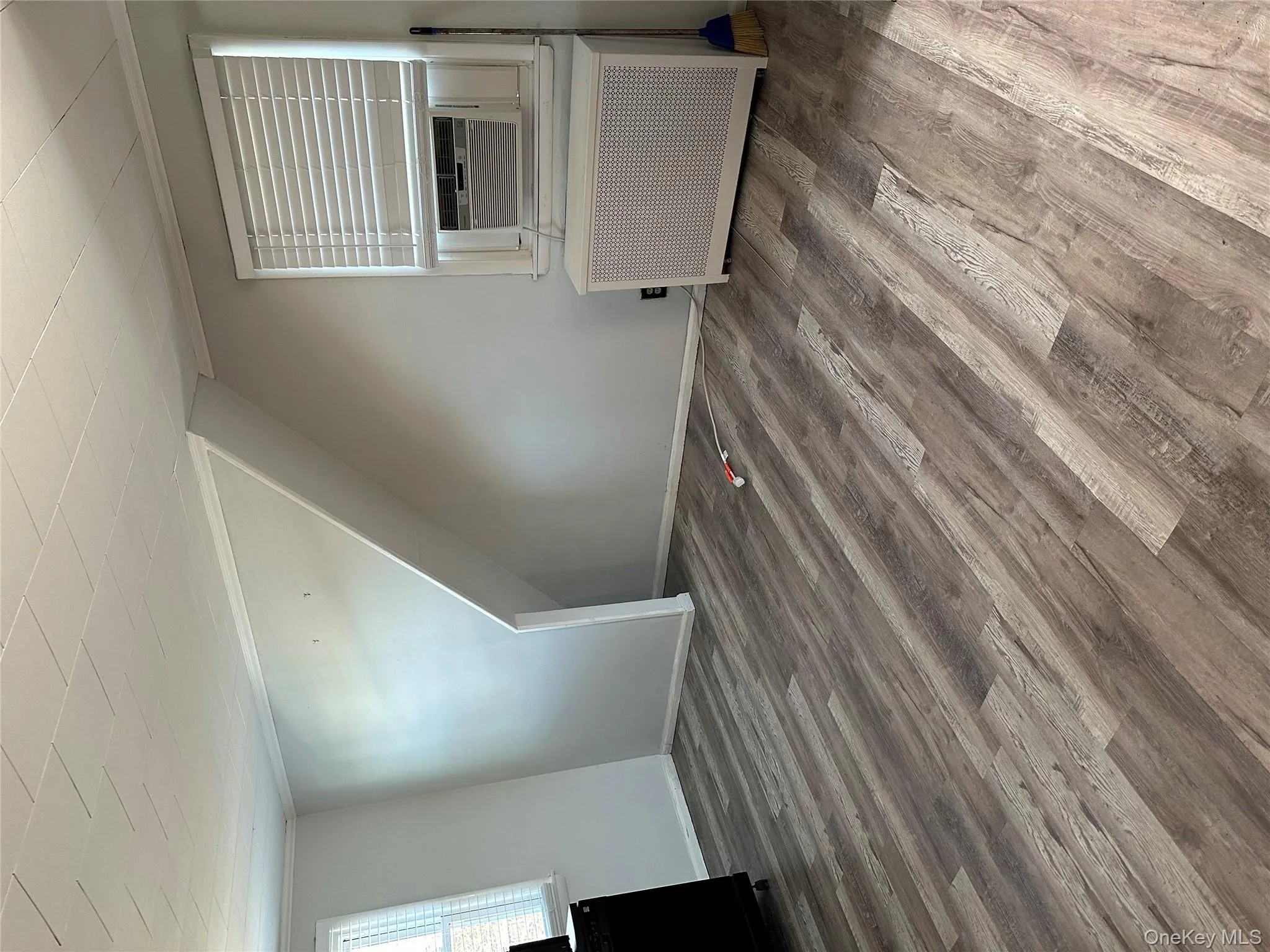 Bonus room with wood finished floors, radiator, and cooling unit Bonus room with wood finished floors, radiator, and cooling unit