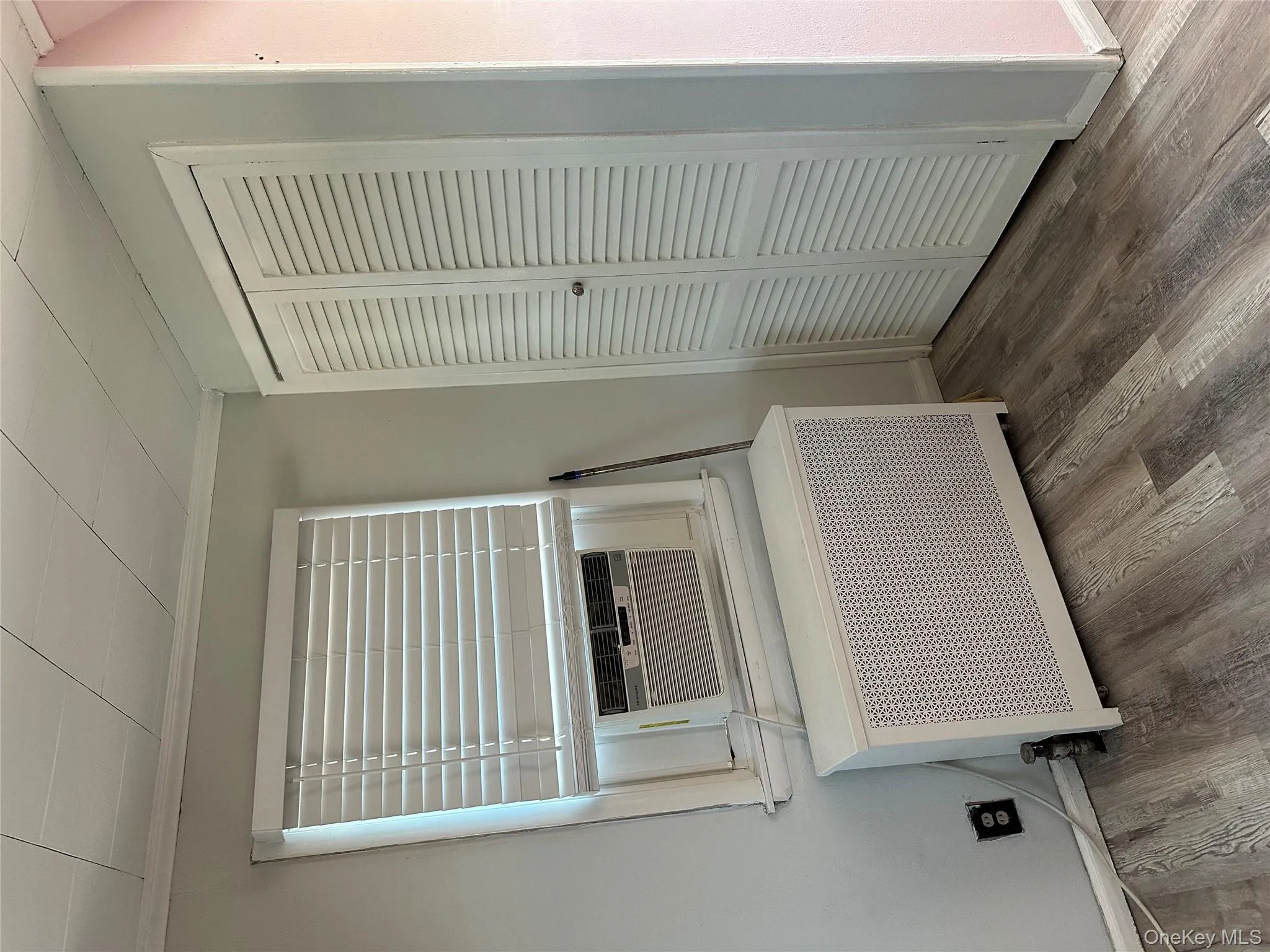 Detailed view of crown molding, wood finished floors, radiator heating unit, and cooling unit Detailed view of crown molding, wood finished floors, radiator heating unit, and cooling unit