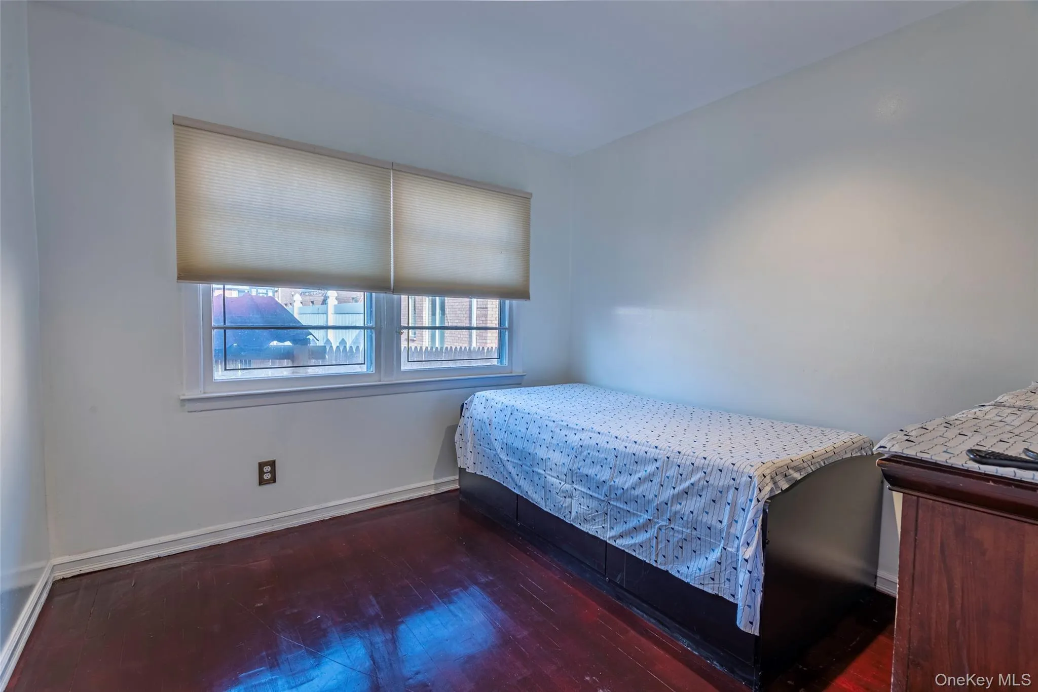 Bedroom featuring baseboards and dark wood-style floors Bedroom featuring baseboards and dark wood-style floors