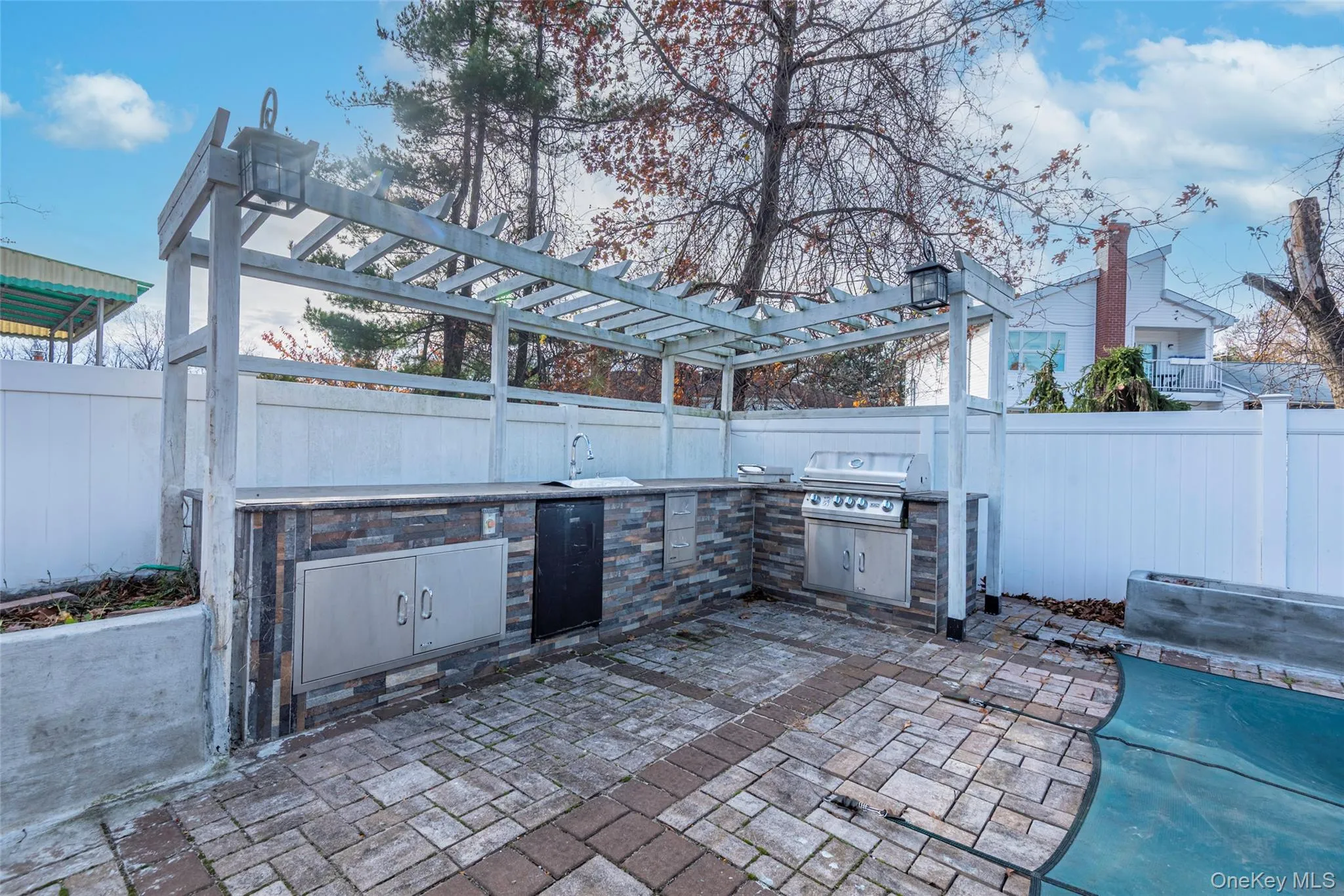 Fenced backyard with a patio, a pergola, and area for grilling Fenced backyard with a patio, a pergola, and area for grilling
