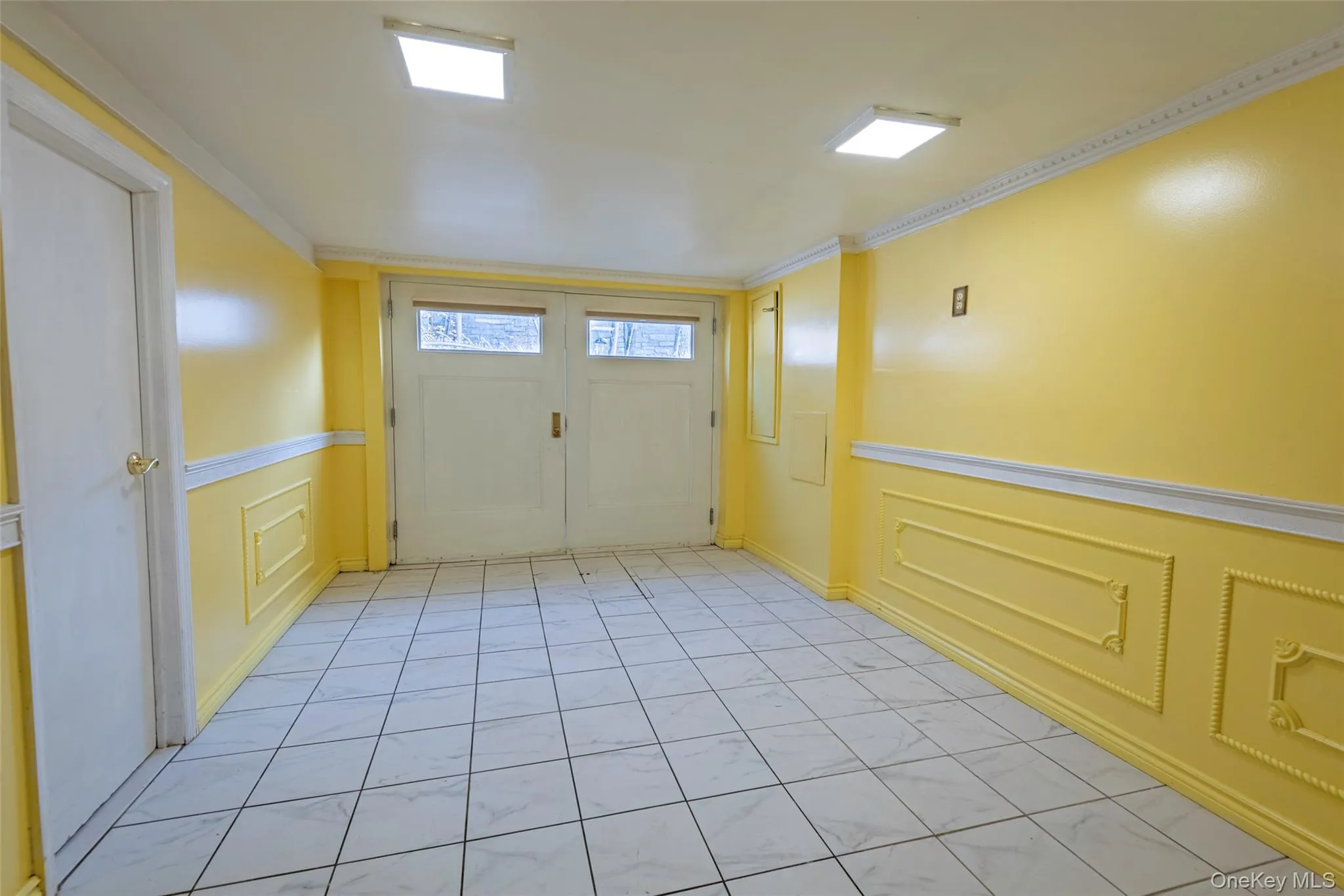 Foyer with a decorative wall, crown molding, and wainscoting Foyer with a decorative wall, crown molding, and wainscoting