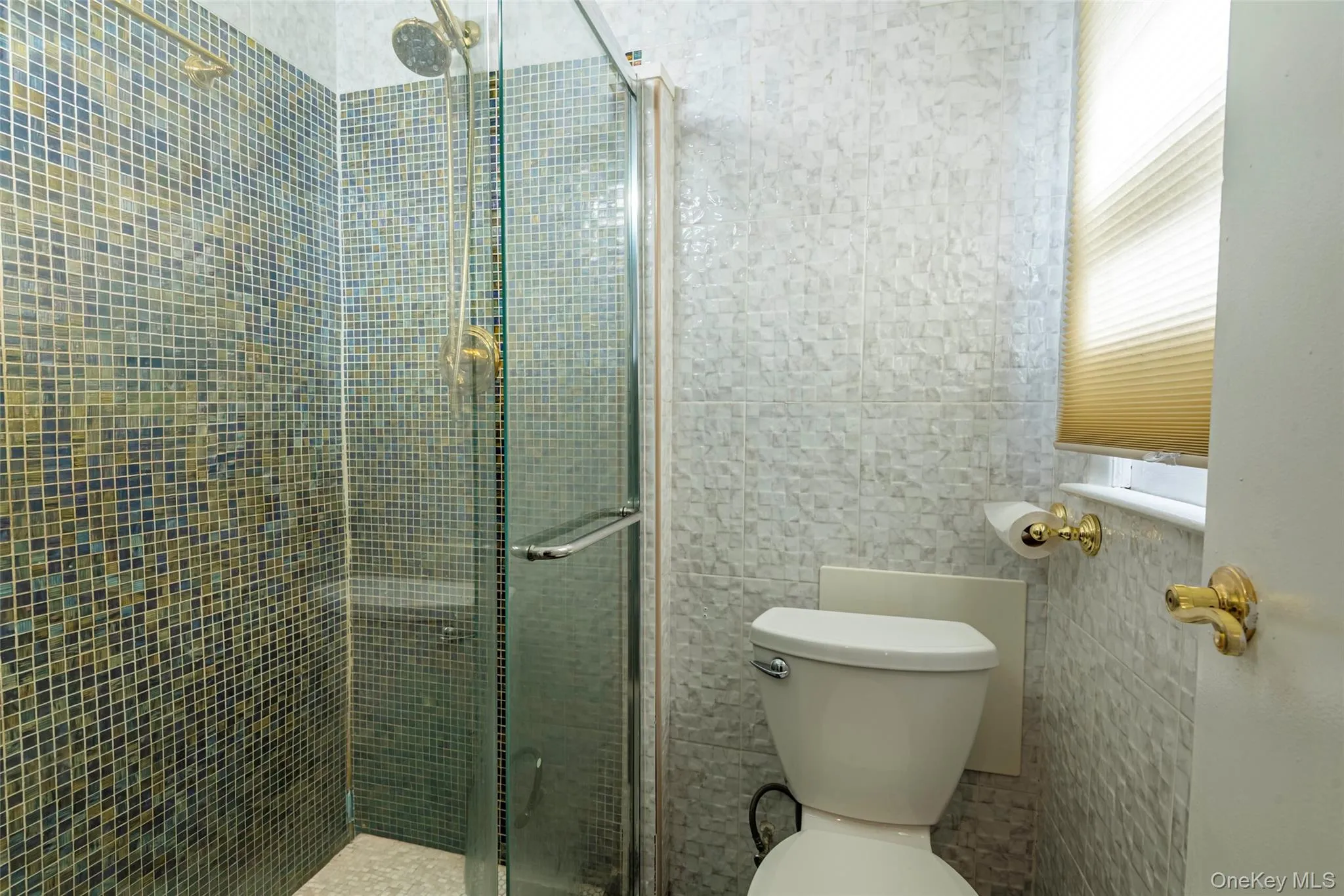 Full bath with a shower stall and tile walls Full bath with a shower stall and tile walls