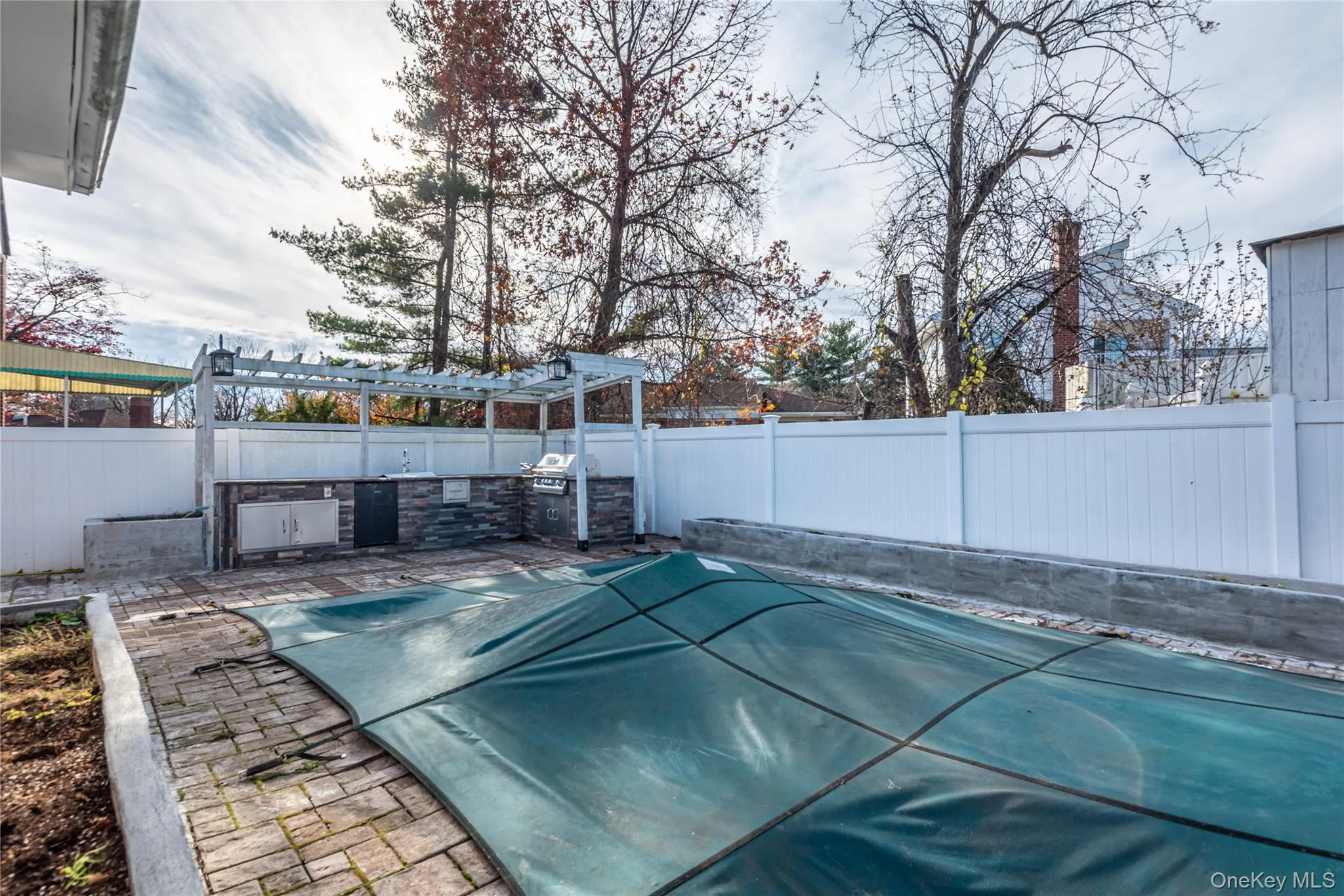 View of pool featuring a fenced backyard, a pergola, an outdoor kitchen, and a patio area View of pool featuring a fenced backyard, a pergola, an outdoor kitchen, and a patio area