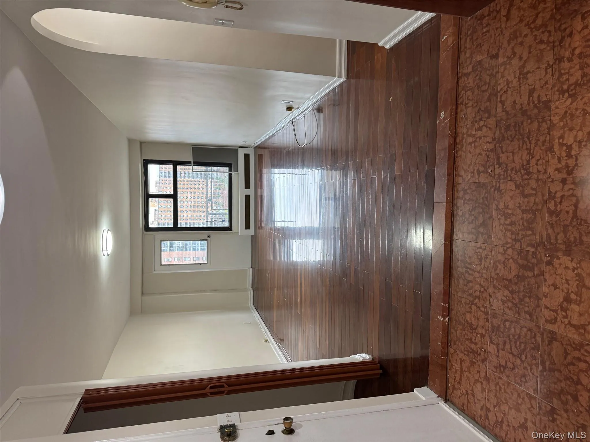 Empty room featuring dark wood-type flooring and arched walkways Empty room featuring dark wood-type flooring and arched walkways