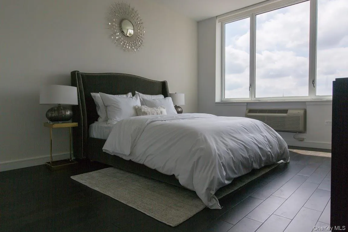 Bedroom with a wall mounted air conditioner and baseboards Bedroom with a wall mounted air conditioner and baseboards