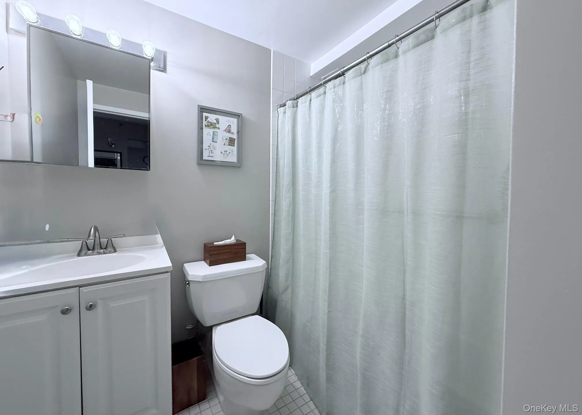 Bathroom featuring a shower with curtain, light tile patterned floors, and vanity Bathroom featuring a shower with curtain, light tile patterned floors, and vanity
