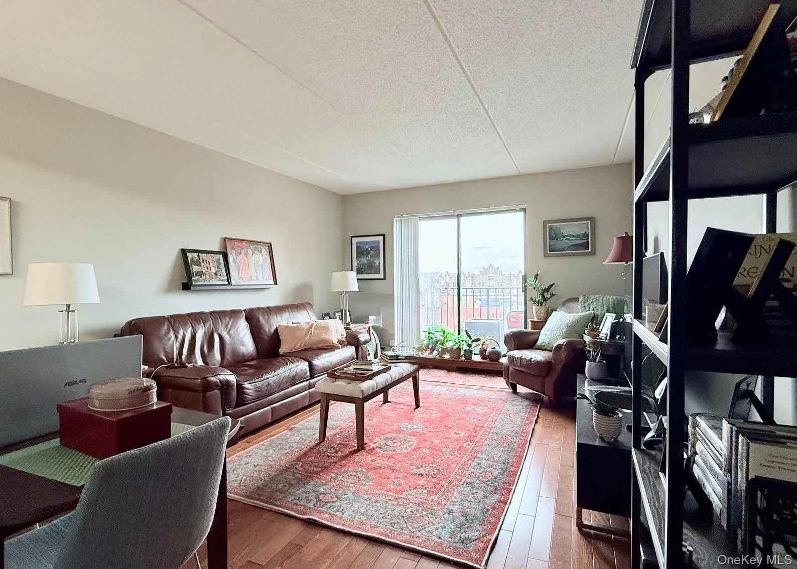Living room featuring hardwood / wood-style flooring and a textured ceiling Living room featuring hardwood / wood-style flooring and a textured ceiling
